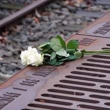 Eine weiße Rose liegt am Mahnmal Gleis 17. | © Deutsche Bahn AG / Volker Emersleben