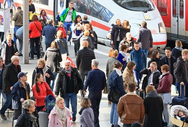 Eine große Zahl von Reisenden an den Gleisen eines Bahnhofs. | © Deutsche Bahn AG / Uwe Miethe